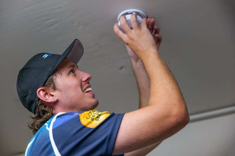 Electrician fitting a smoke alarm